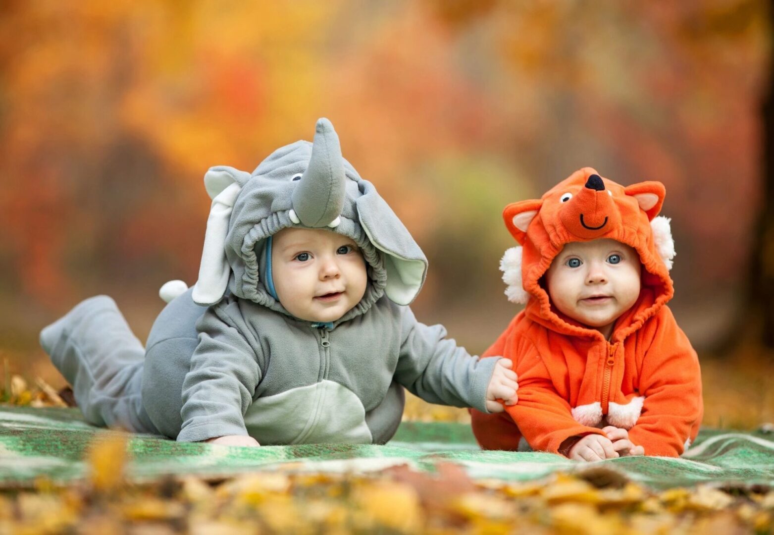 two babies wearing costume outdoors